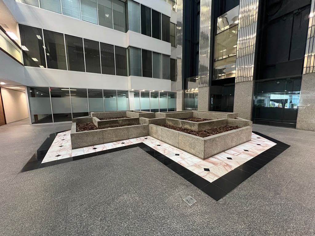 Finished commercial atrium with marble flooring and planter courtyard