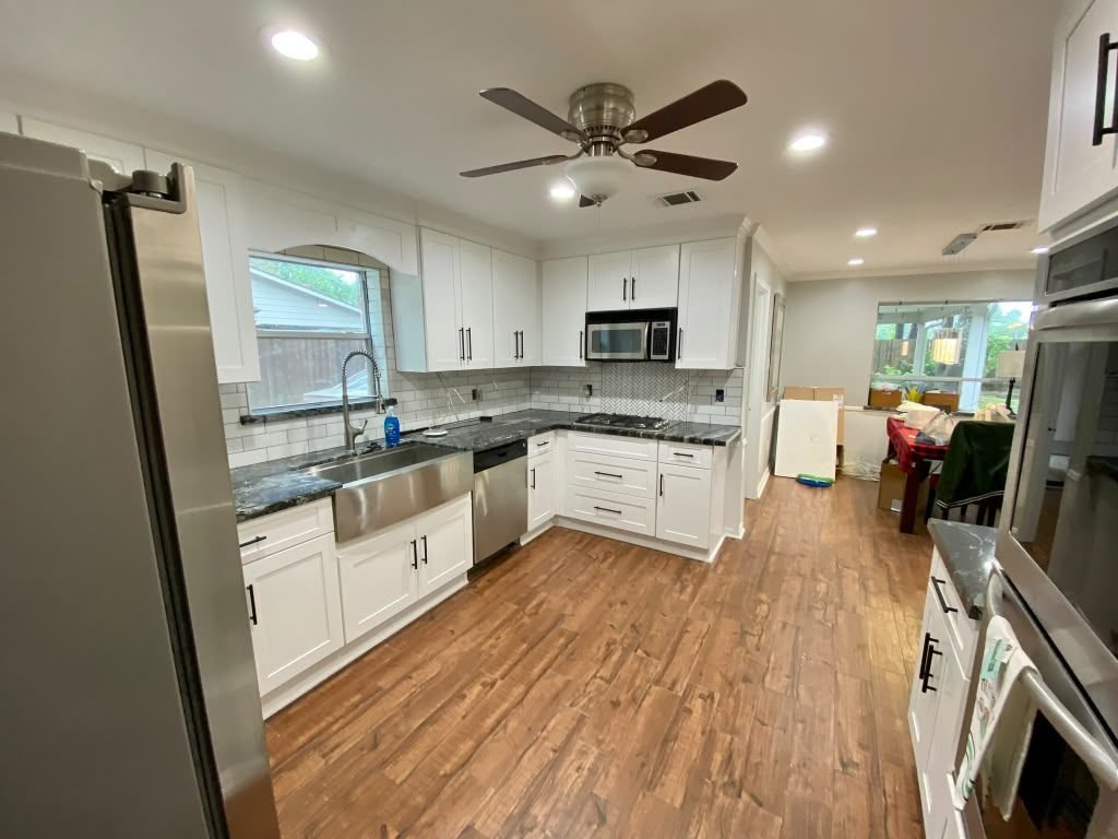 Finished kitchen remodel with white cabinetry and granite counters